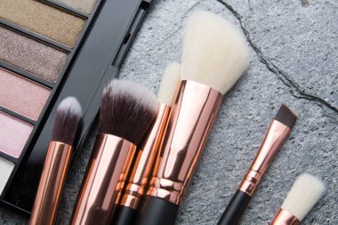 koyu arka plan üzerinde çeşitli makyaj ürünleri 