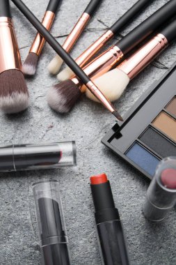 koyu arka plan üzerinde çeşitli makyaj ürünleri 