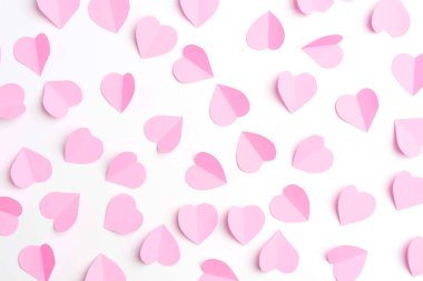 Pembe kağıt kalpleri üzerinde beyaz izole