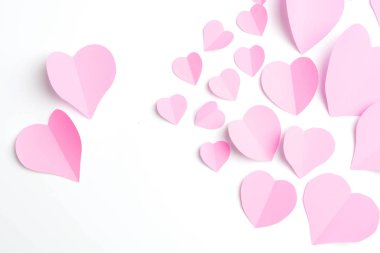 Pembe kağıt kalpleri üzerinde beyaz izole