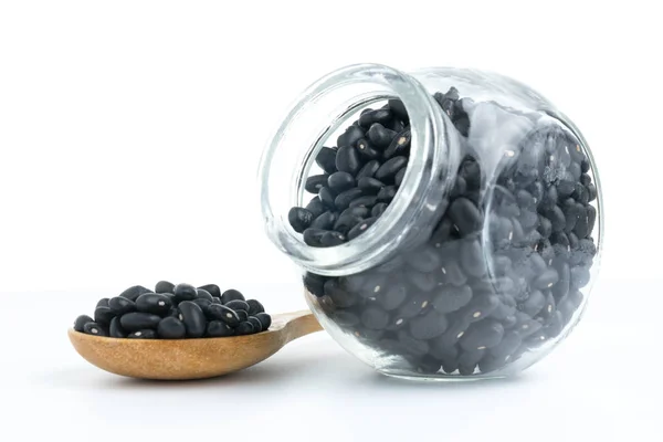 Black beans on glass bottles with white — Stock Photo, Image