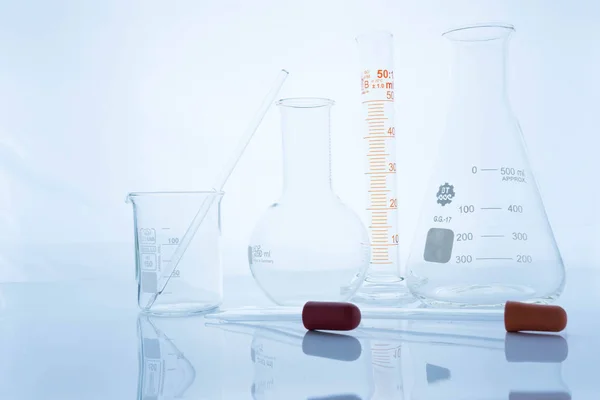 Különböző laboratóriumi üvegeszközök és tükörképe — Stock Fotó