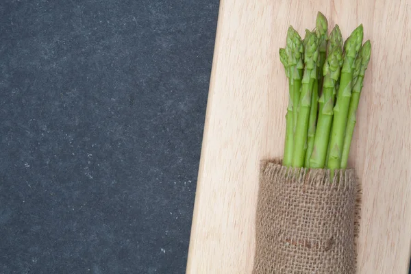 Bunch of asparagus over chopping wood — Stock Photo, Image