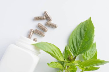 bir şişe beyaz zemin üzerine dışarı dökülmesini ot kapsül