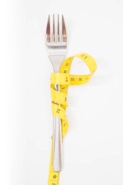 bir ölçüm bandı diyet veya sağlıklı beslenme ile çatal 