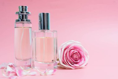 Pembe arka planda parfüm şişeleri