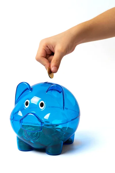Mão de banco porquinho azul colocando moeda no branco — Fotografia de Stock