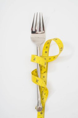 bir ölçüm bandı diyet veya sağlıklı beslenme ile çatal 