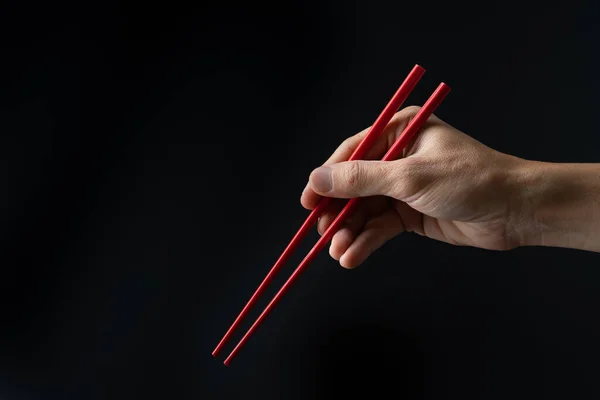 Χέρι Κρατώντας Chopsticks Έτοιμο Τρώνε Μαύρο Φόντο — Φωτογραφία Αρχείου