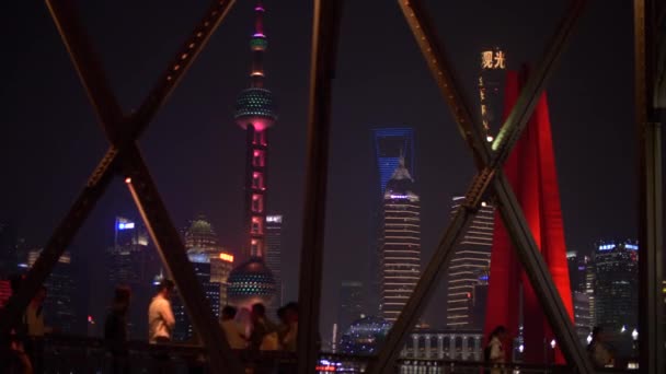 Шанхай - 30 жовтня 2019: Автобуси і автомобілі на нічному мості перед Шанхаєм Скайлайн і Перл Тауер — стокове відео