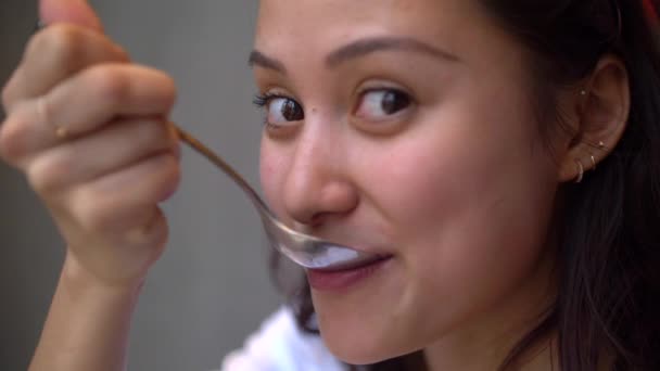 Attraktive gemischte Mädchen isst Kuchen und lächelt in die Kamera Nahaufnahme slo mo 4k — Stockvideo