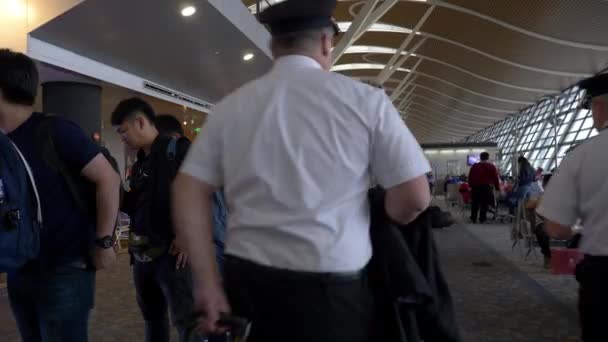 Zwei Piloten mit Koffern gehen am Flughafen Shanghai Pudong am Boarding Line vorbei — Stockvideo