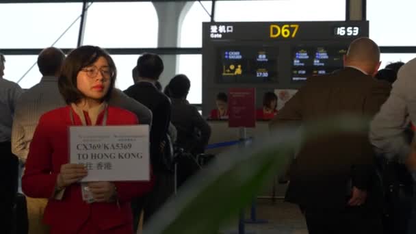 Vertegenwoordiger van het personeel van de luchtvaartmaatschappij houdt een handtekening bij Gate op Shanghai Pudong Airport — Stockvideo