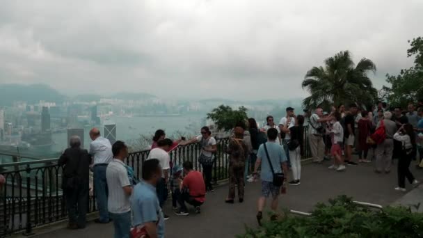 Οι τουρίστες Απολαύστε τη θέα του Χονγκ Κονγκ Victoria Bay από Victoria Peak Cloudy 4k — Αρχείο Βίντεο