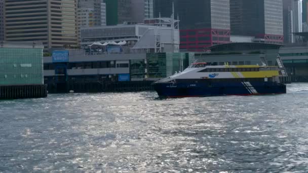 Гонконгский паром протаранил залив Виктория со зданиями позади на облачном Day4k — стоковое видео