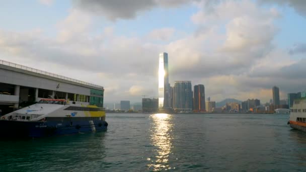 Barco de Hong Kong na baía de Victoria com sol refletindo do arranha-céu de vidro 4k — Vídeo de Stock