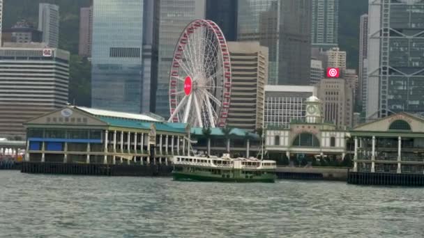 Hong Kong Star Ferry na Victoria Bay opouští molo s Ferris Wheel 4k — Stock video