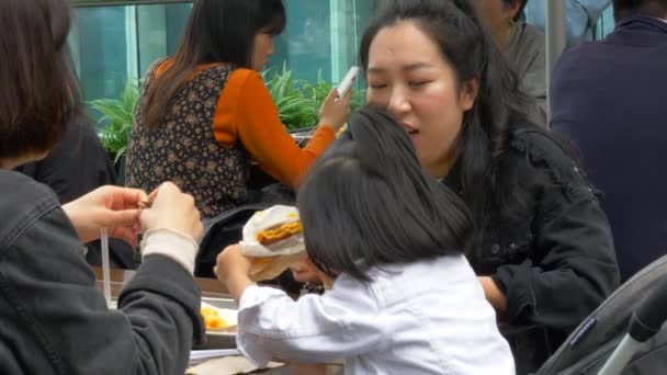 香港- 2019年4月30日：亚洲家庭饮食汉堡在香港商城外桌 — 图库视频影像