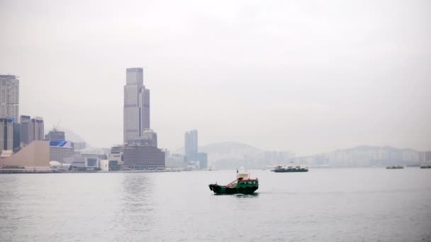 Piccola barca su Victoria Bay a Hong Kong con edifici alle spalle, 4k — Video Stock