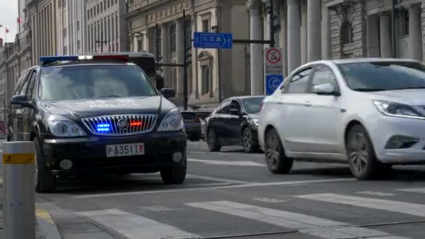Автобусы и автомобили проезжают мимо полицейской машины с мигающими огнями — стоковое видео