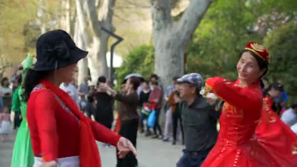 Hombres y mujeres asiáticos vestidos con trajes tradicionales bailan en Shanghai Park 4k — Vídeo de stock