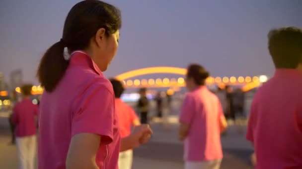 Azjaci mężczyźni i kobiety ćwiczyć razem na placu w Szanghaju 4k nocy 4k — Wideo stockowe