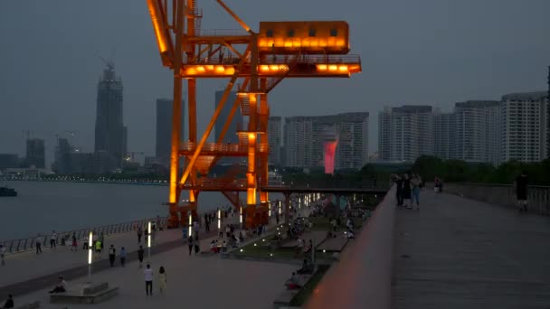 Ludzie spacerują wzdłuż rzeki Huangpu w Szanghaju przez Lit Steel Structure, Noc, 4k — Wideo stockowe