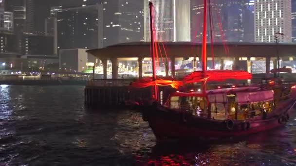 Jasna łódź z czerwonymi żaglami Odpływa nocą w wielkim mieście 4k — Wideo stockowe