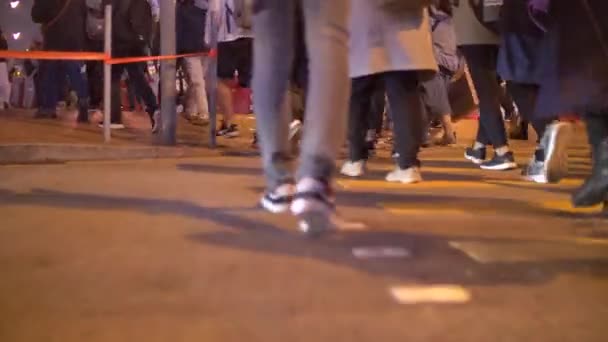 Пешеходы, переходящие улицу Ноги крупным планом ночью 4k — стоковое видео