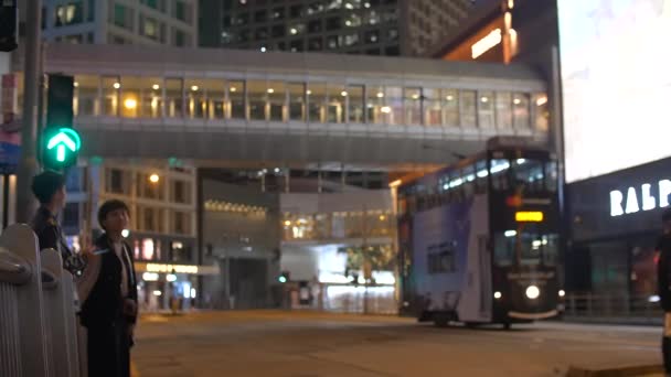 Junge asiatische Männer und Frauen warten darauf, dass die Straßenbahn vorbeifährt, um nachts die Straße zu überqueren 4k — Stockvideo