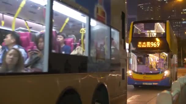 Double Decker Buses Drive past a Stop at Night in Hong Kong 4k — Stock Video