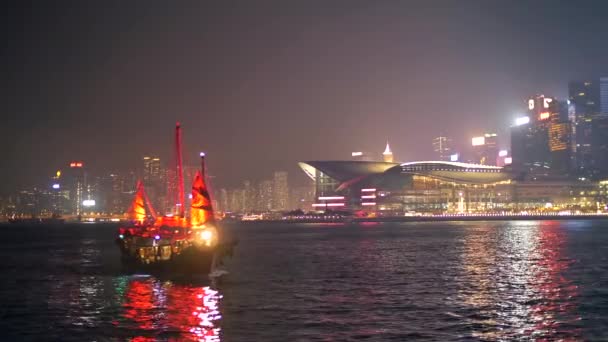 Barca brillantemente illuminata con vele rosse che si avvicinano di notte in una grande città 4k — Video Stock