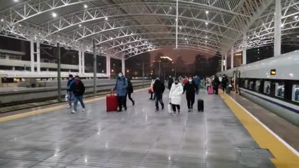 在中国，戴口罩的手提箱的人走下火车 — 图库视频影像
