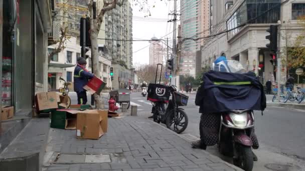 Люди в масках выбрасывают коробки на улицу в Китае — стоковое видео