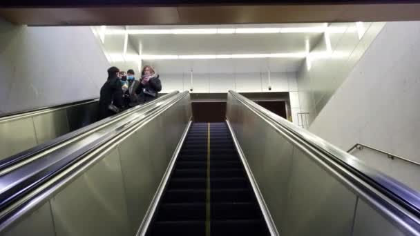 Escada rolante de metrô vazia com poucas pessoas todas usando máscaras — Vídeo de Stock