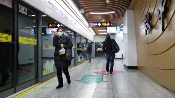 Zwarte persoon draagt medische masker Waits voor trein op leeg station in China — Stockvideo