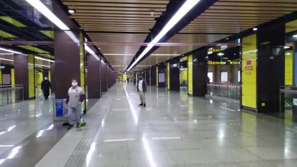 Weinig mensen dragen medische maskers op een leeg metrostation in China — Stockvideo