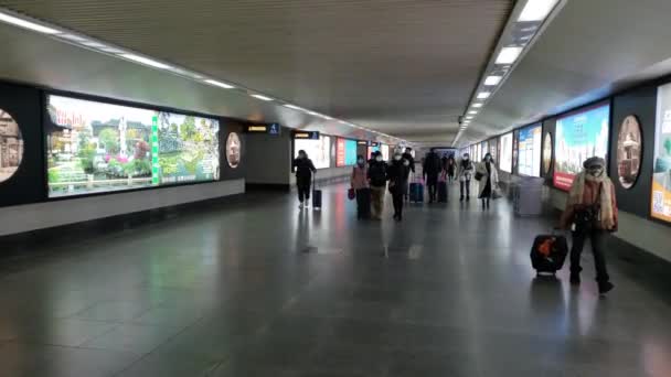 Mensen dragen maskers lopen naar beneden metro Underpass met koffers in China — Stockvideo