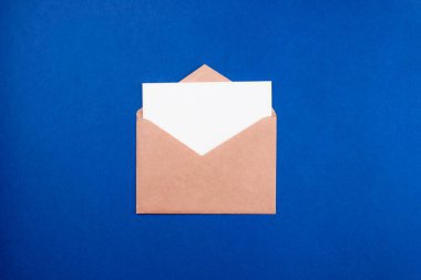 Zarfta beyaz kağıt harf düz renkli arka plan üzerinde yatıyordu. Kopyalama alanı olan üst görünüm. İletişim, ABC kavramı. Asgari biçim şablonu, ağ için maket, sosyal medya.