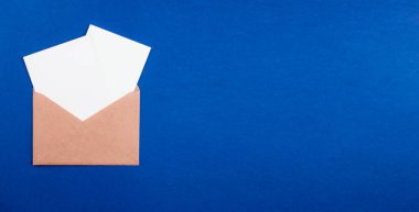 Zarfta beyaz kağıt kağıtlar düz renkli arka plan üzerinde yatıyordu. Kopyalama alanı olan üst görünüm. İletişim, ABC kavramı. Asgari biçim afiş şablonu, ağ için maket, sosyal medya.