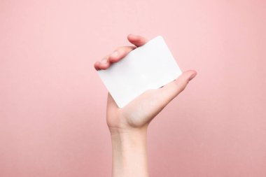 Renkli pembe arka planda beyaz kartvizit tutan bir kadın. Şablon, model, ağ için boş, sosyal medya, fotokopi alanı ile reklam. Pazarlama, teknoloji konsepti. Stok fotoğrafı.