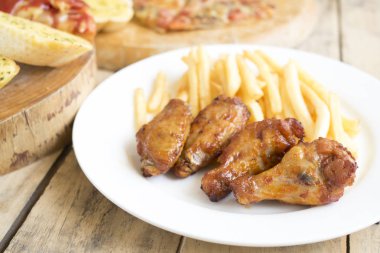 Fast food, çıtır tavuk kanatları, ekmek, patates kızartması ve pizza üzerinde 