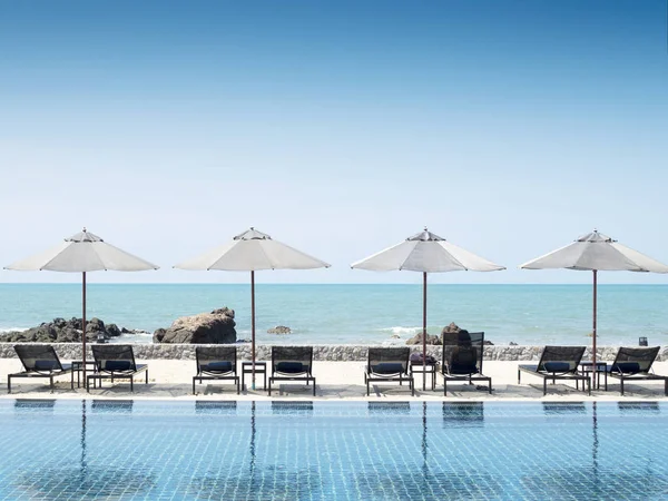 Sonnenschirm und Schwimmbad im Hotelresort mit Meeresstrand — Stockfoto