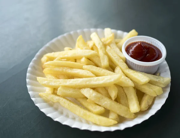 Close-up van Franse frietjes aardappelen met ketchup op witte schotel. — Stockfoto