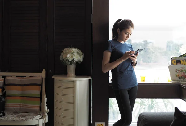 Asian woman relax, texting on mobile phone.