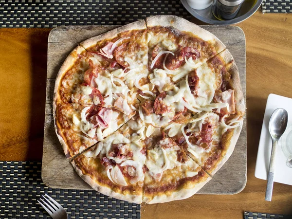 Vista superior da saborosa fatia de pizza com bacon no lugar de madeira . — Fotografia de Stock