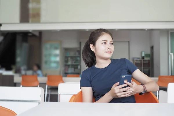 Asiatisk kvinde slappe af, Læsning og skrive på mobiltelefon . - Stock-foto