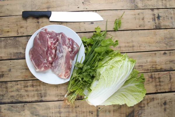 Νωπό χοιρινό κρέας και λαχανικά για το ξύλινο τραπέζι. — Φωτογραφία Αρχείου