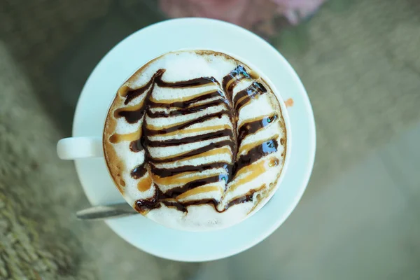 Café com leite quente com cobertura em copo de vidro. Vista de cima . — Fotografia de Stock