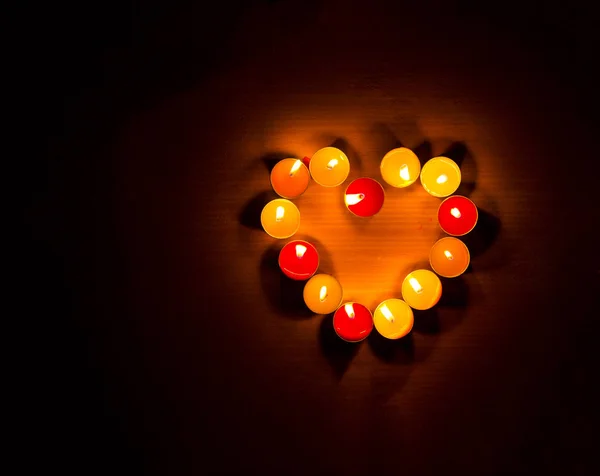 Κεριά φως στην καρδιά σχήμα, μαύρο φόντο. — Φωτογραφία Αρχείου